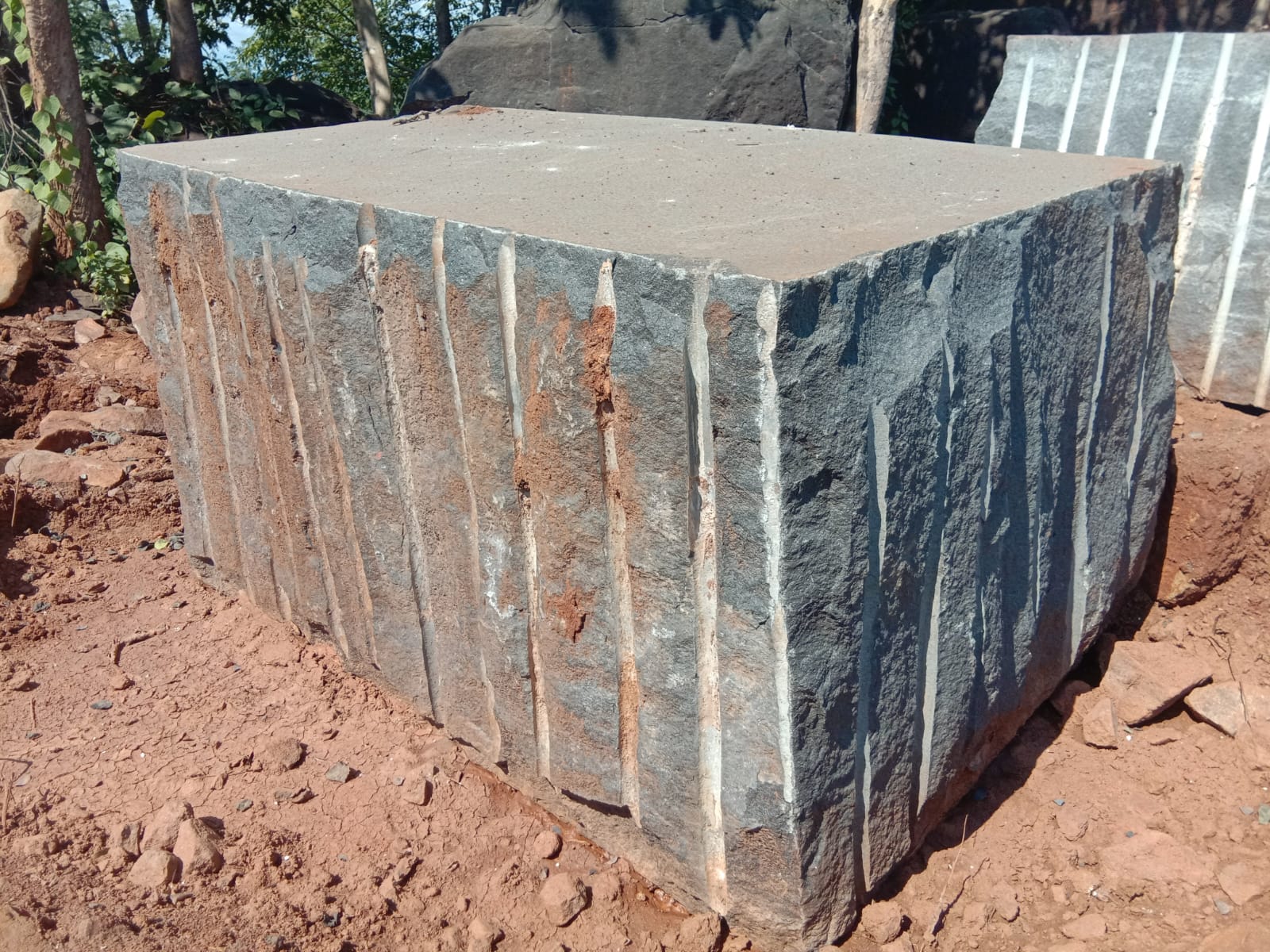 Rough-dressed premium black granite block at quarry yard