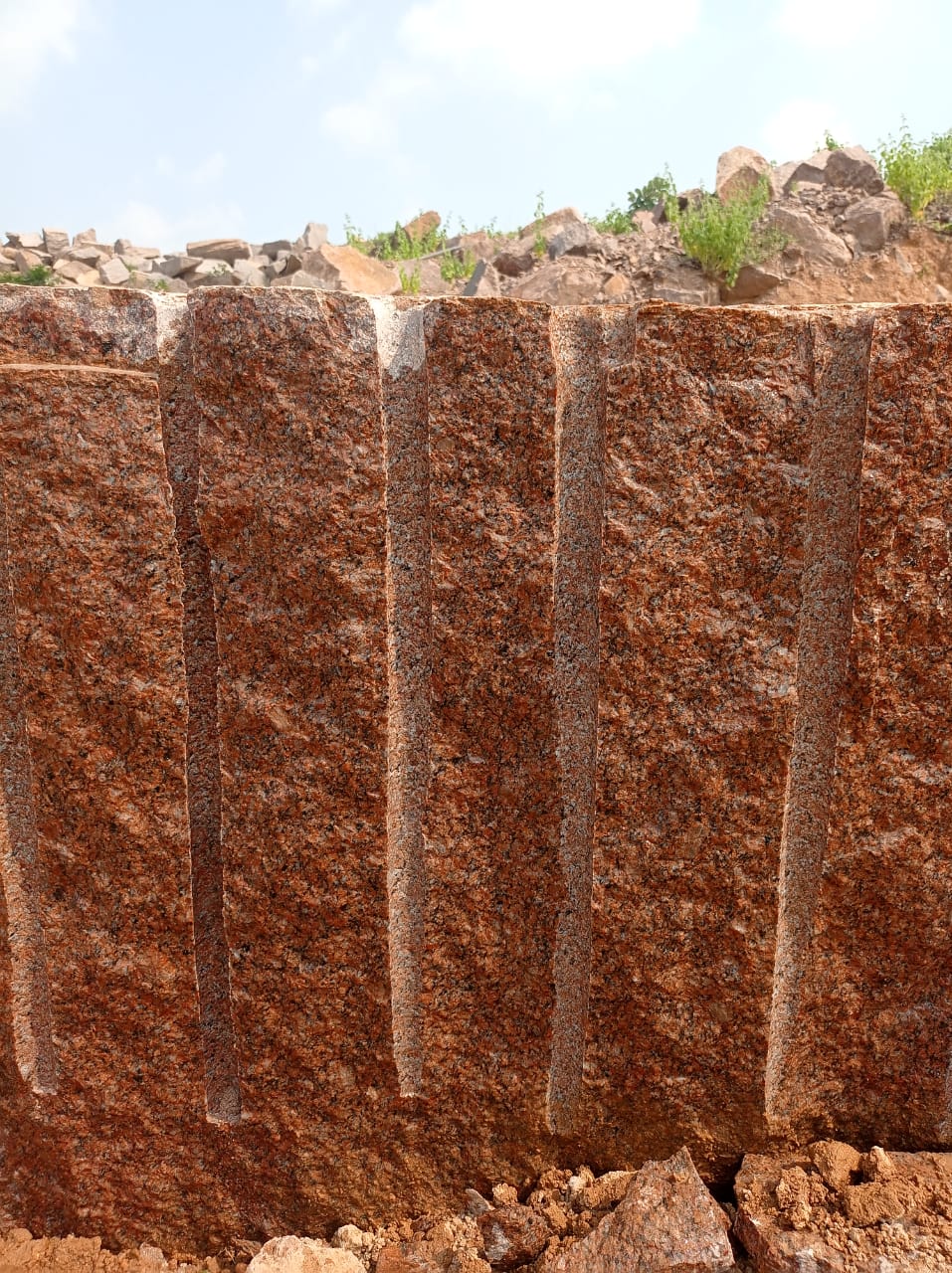 Ruby red multicolour granite quarry face in South India